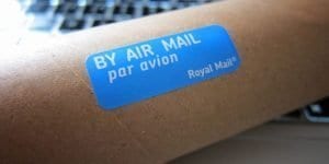 blue airmail sticker on brown cardboard cylinder
